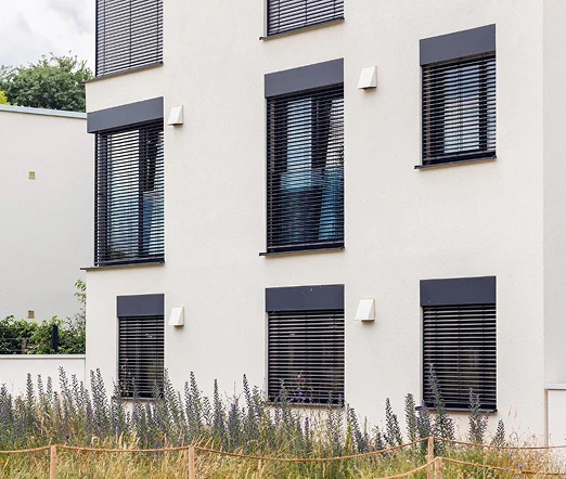 Außenjalousien an einem modernen Mehrfamilienhaus mit weißen Fassaden