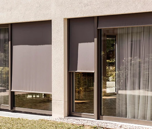 Außenrollos in Grau an einer modernen Fassade, Sonnenschutz für große Fenster