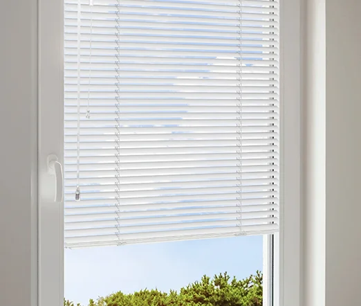 Klassische weiße Jalousien am Fenster, teilweise heruntergelassen